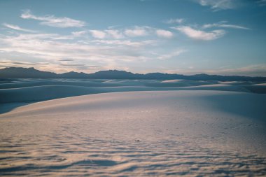 New Mexico 'daki White Sands Ulusal Parkı' ndaki kar beyazı çöl kum tepelerinin mavi gökyüzüne karşı nefes kesici manzarası.