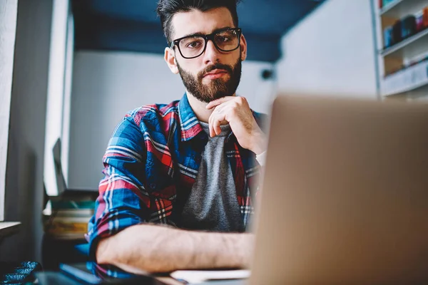 Gözlük kamera dizüstü bilgisayar, yakışıklı erkek üzerinde önemli web konuşma sonra geliştirici bakarak ciddi hipster adam portresi modern netbook ile çalışma kafeteryada rahat giyinmiş