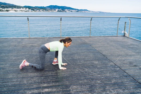 運動中の白人女性ボードウォーク桟橋での朝のトレーニング中の努力持久力とスタミナの練習を行う — ストック写真