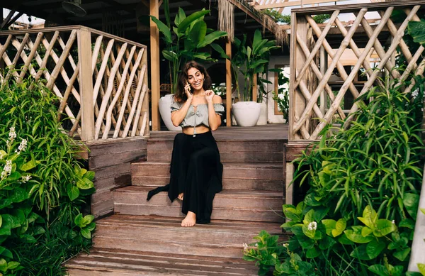 Positiv Barfota Kvinnlig Snygg Outfit Talar Smartphone Känslomässigt Medan Sitter — Stockfoto