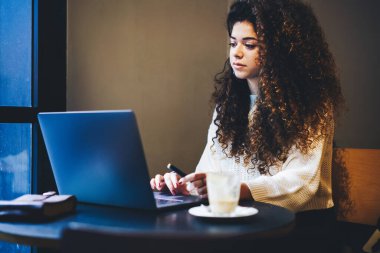  Millennial hipster kızı internet bağlantısı 4G olan internet sayfası kullanıyor. Mesafeli iş yapmak ya da kahve dükkanında öğrenmek için.