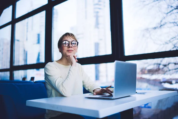 Glad Female Freelancer Casual Clothes Eyeglasses Looking Camera Sitting Table — Stockfoto