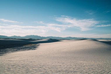 ABD 'nin New Mexico eyaletindeki White Sands Ulusal Parkı' nda güneş ışığı alan geniş ve eşsiz bir kum tepeciği.
