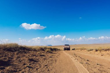Torysh Balo Vadisi 'nin resimli manzarası ve güneşli yaz günlerinde araba sürerken lastik izleri bırakan araba.