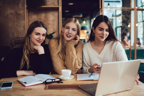 Usmívající Mladé Ženy Sedí Stolu Moderní Kavárně Prohlížení Internetu Notebooku — Stock fotografie