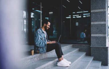 Modern netbook teknolojisi üzerine yazılım geliştiren gözlüklerdeki mutlu erkek programcı 4G internete bağlanıyor