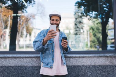 Kahveli neşeli erkek blogcu, gezinen internete bağlanarak tek başına seyahat ederken video bloğu çekmeye gidiyor.