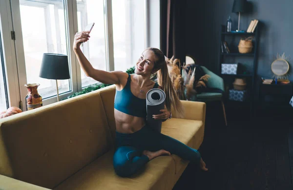 Gadis Eropa Dengan Tikar Kebugaran Duduk Sofa Dan Mengambil Selfie — Stok Foto