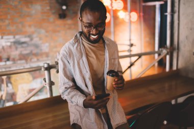  Akıllı telefon uygulaması ve gülümseme ile mesajlaşan mutlu Afrikalı Amerikalı adam