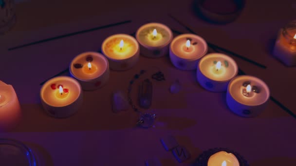 Chacra-Kerzen mit Quarz-Pendelkristallen, Räucherstäbchen, hölzernen Runen — Stockvideo