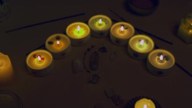 Chakra sembollü statik esrarengiz mumlar. Mistik kristaller ve fal sarkaçları. Tahta parçalarda runik semboller. Sanatsal amaçlar için kasıtlı olarak tahıl eklendi. 