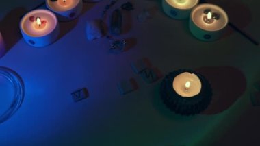 Tütsü çubukları, kuvars kristalleri ve sihirli çakra sarkacıyla mum alevi. Sanatsal amaçlar için kasten tahıl eklendi. Esrarengiz Budizm içeriği.