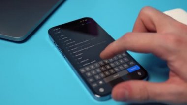 Netflix 'i bir iPhone' da App Store 'dan aranıyor ve indiriliyor. Mavi arkaplandaki bir telefona bir uygulama indiriliyor. Mykolaiv, Ukrayna, 6 Temmuz 2022. 