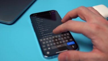 Bir iPhone 'da Uygulama Mağazası' ndan YouTube aranıyor ve indiriliyor. Mavi arkaplandaki bir telefona bir uygulama indiriliyor. Mykolaiv, Ukrayna, Temmuz 06 2022. 