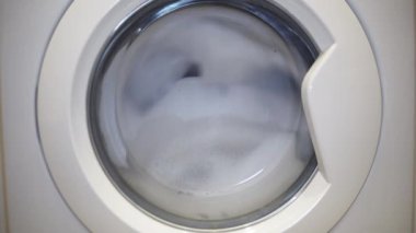 Beyaz çamaşır makinesi. Renkli giysileri çamaşır deterjanıyla temizliyorum.. 