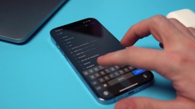 Bir iPhone 'da Uygulama Mağazasından Yıldırım Atar aranıyor ve indiriliyor. Mavi arkaplandaki bir telefona bir uygulama indiriliyor. Mykolaiv, Ukrayna, Temmuz 06 2022. 