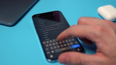 Searching for and downloading PayPal from the App Store on an iPhone. Downloading an application on a phone on a blue background. Mykolaiv, Ukraine, July 06 2022. 