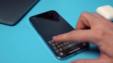 Uygulama mağazasından bir iPhone 'dan Twitter indiriliyor ve aranıyor. Mavi arkaplandaki bir telefona bir uygulama indiriliyor. Mykolaiv, Ukrayna, Temmuz 06 2022. 