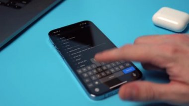 TikTok 'u bir iPhone' da App Store 'dan aranıyor ve indiriliyor. Mavi arkaplandaki bir telefona bir uygulama indiriliyor. Mykolaiv, Ukrayna, Temmuz 06 2022. 