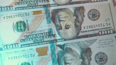 Yüzeyde sırayla 100 dolarlık banknotlar var. Yapay ışık. 