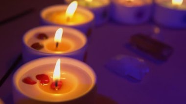 Kurumuş bitkilerle mumlar kapanıyor. Arka planda tütsü ve gül kuvars kristalleri. 