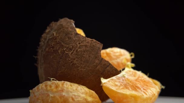 Pół Kokosa Dojrzałymi Plastrami Pomarańczy Obrocie — Wideo stockowe