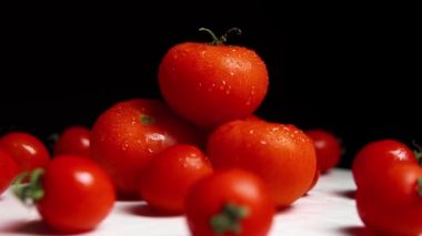 Fresh washed ripe red tomatoes on the white surface. The front view with slow rotation.