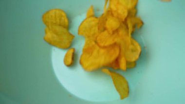 Potato chips falling into a blue bowl. Preparing to watch a movie. High quality FullHD footage