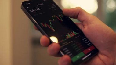 Businessman scrolling on his phone chart of BTC cryptocurrency value. Bitcoin value chart