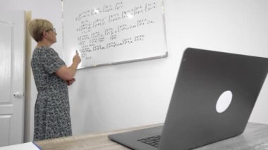 Aged mathematics teacher in glasses is preparing the students to important exams online lesson, distance education.