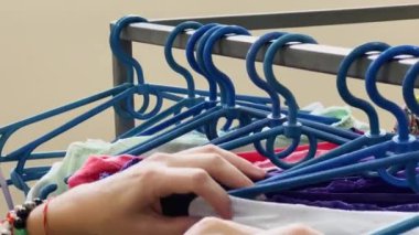 Girl chooses underwear in the store. Clothes on plastic hangers. High quality 4k footage