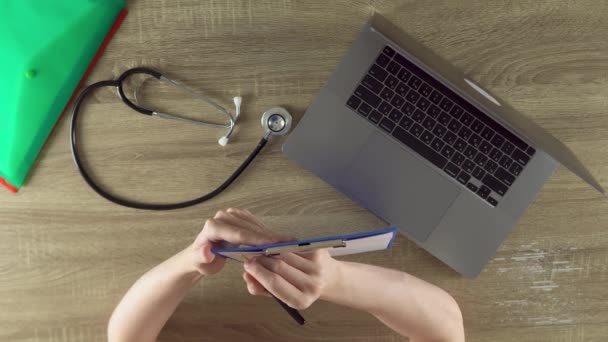 Physician Listening Patient Writing Symptoms Files Notebook Stethoscope Laptop Wooden — Stock video