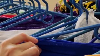 Girl chooses underwear in the store. Clothes on plastic hangers. High quality 4k footage