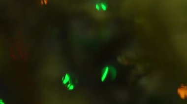 The celebration of New Year. Gift boxes under fir-tree. Bokeh in the branches. Evening scene.