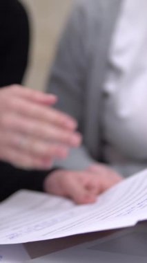 A group of people are discussing documents close-up. Brainstorm. Vertical video. High quality FullHD footage