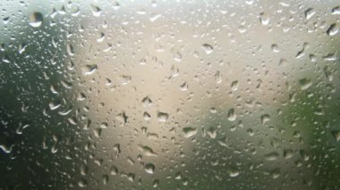 Falling raindrops on the foggy window close up. Rainy weather. Thunderstorm.