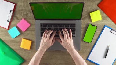 The developer is programming on the laptop. Modern workplace. Green screen mockup.