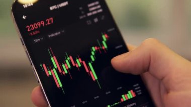 Businessman scrolling on his phone chart of BTC cryptocurrency value. Bitcoin value chart
