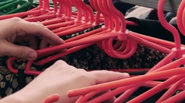 Girl chooses underwear in the store. Clothes on plastic hangers. High quality 4k footage