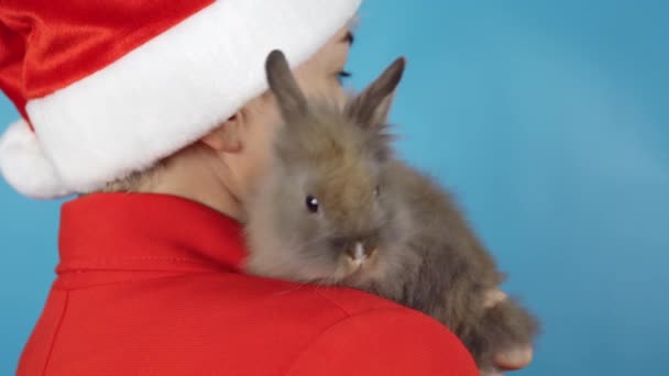 新年的庆祝活动 带着兔子头戴圣诞帽的金发成年妇女 — 图库视频影像