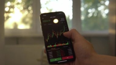 Businessman scrolling on his phone chart of BTC cryptocurrency value. Bitcoin value chart