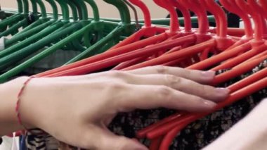 Girl chooses underwear in the store. Clothes on plastic hangers. High quality 4k footage
