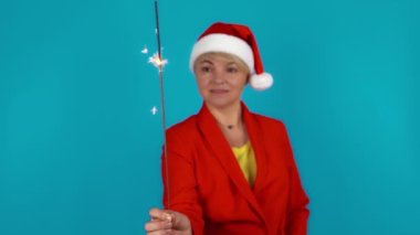 Bengal ateşiyle neşeli yetişkin kadınlar. Gülümseyen kadınlar mavi arka planda bengal ateşi sallıyor. Yeni yıl kostümlü, sarışın ve komik kadınlar..