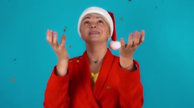 Konfetili yeni yıl krakeri. Şaşırmış kadın krakerden gelen altın sarısının nasıl düştüğünü gözlemliyor. Neşeli bir kadın..