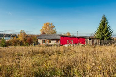 Ağaçların ve gökyüzünün arka planında taştan bir ev.
