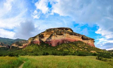 Mantar Kayası 'nın altındaki otlak ovalar Golden Gate Highlands Ulusal Parkı' nda renkli bir kumtaşı çıkıntısı. Burası Güney Afrika 'nın Özgür Eyaleti' nin popüler Clarens kasabası yakınlarındaki bir doğa koruma alanı..