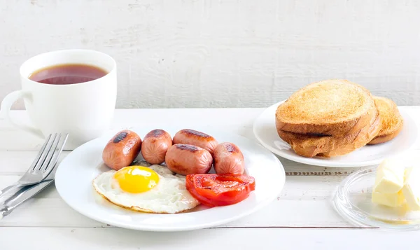 Смажене яйце, міні ковбаски, помідор — стокове фото