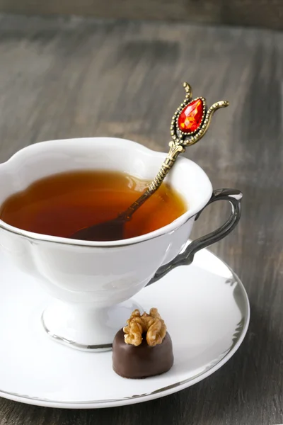 Cup of tea and chocolate candy with walnut — Stock Photo, Image