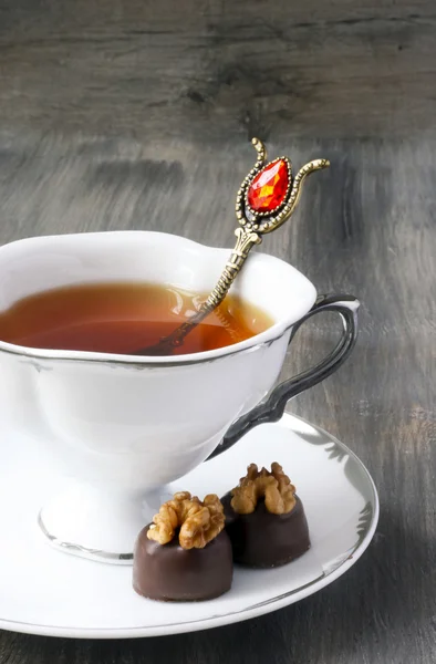 Cup of tea and chocolate candies with walnut — Stock Photo, Image
