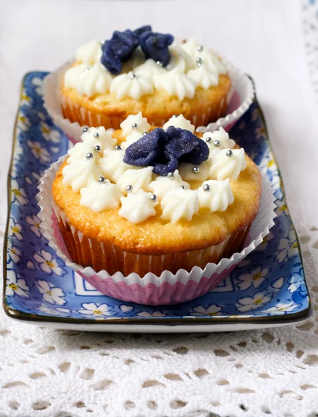 Cupcakes with candied violet flowers — Stock Photo, Image
